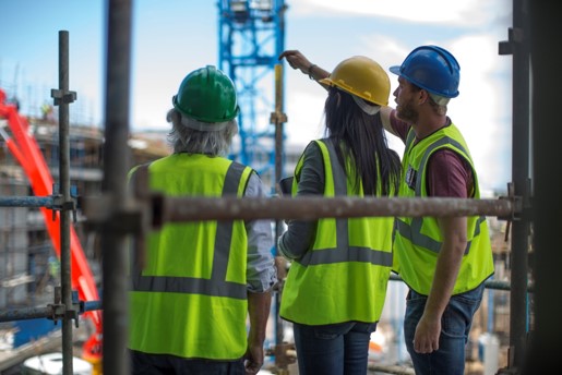 Three construction workers in hi-viz vests.