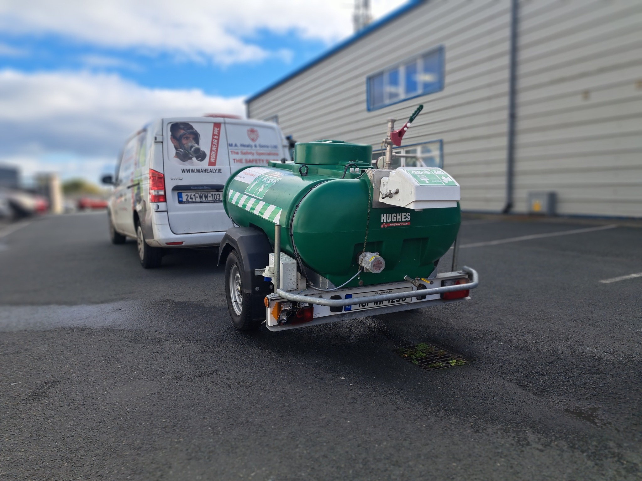 A mobile safety shower tank behind a van.
