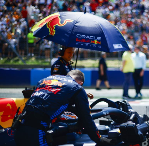Man wearing a racing suit under a Sparco racing umbrella